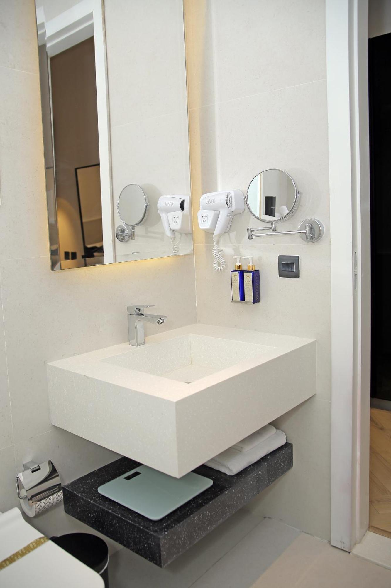 Ambiance Boutique Art Hotel Lahore Habitación foto A wall mounted hair dryer in a hotel bathroom